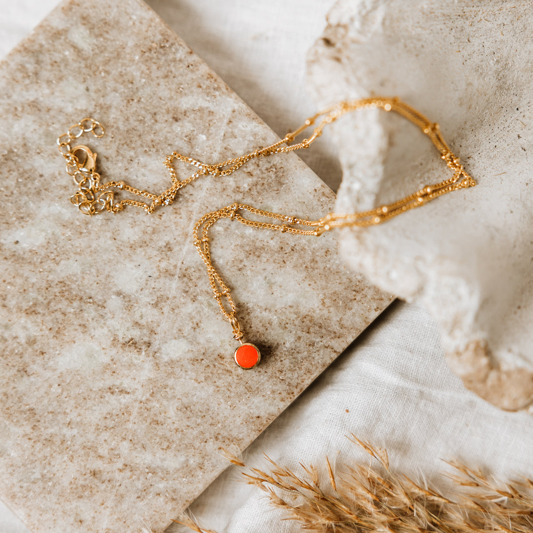 Gold satellite necklace with red enamel dot charm